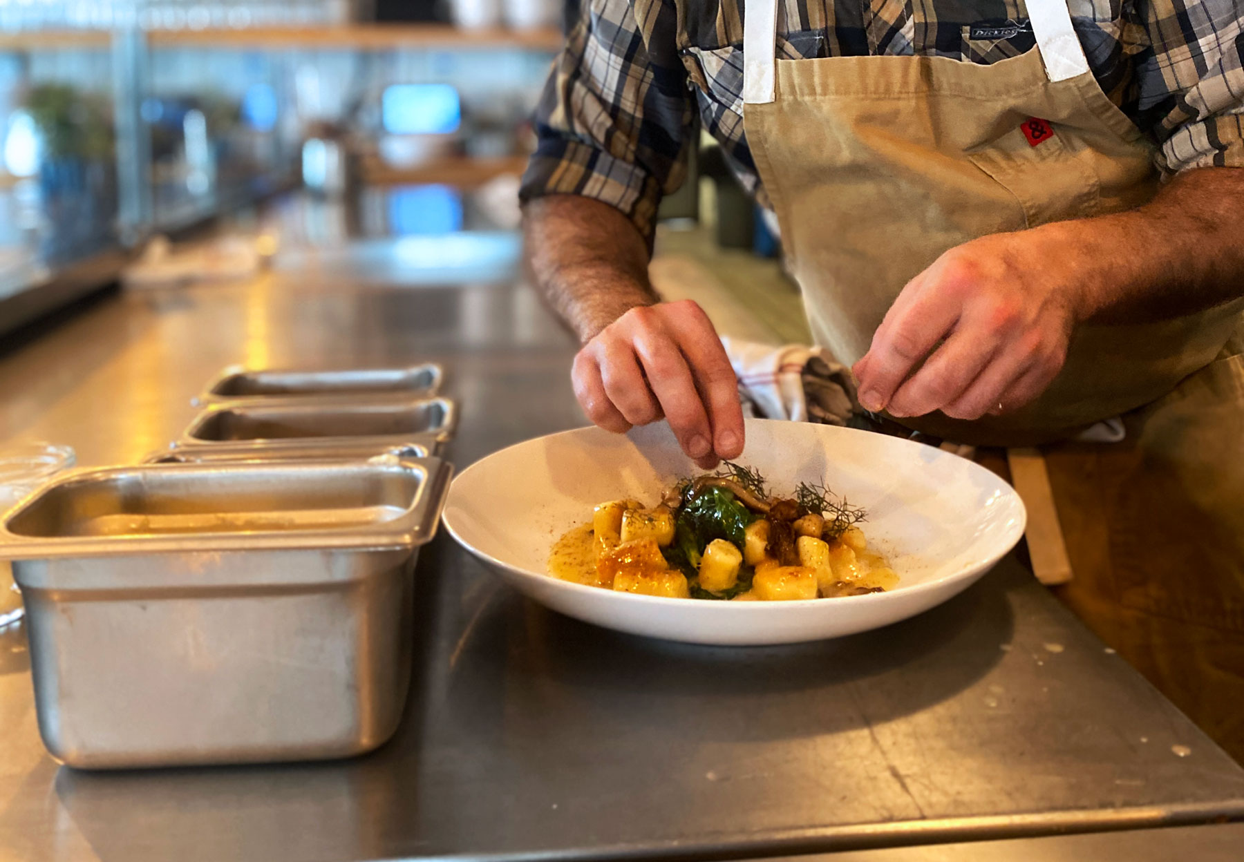 Chef Nathan Lemley garnishing a dish at Foreign and Domestic in Austin, Texas.